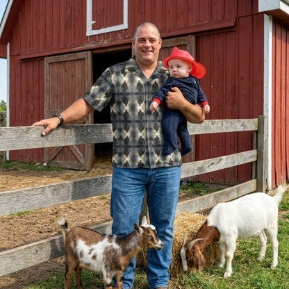 "Frankenstein" men’s Hawaiian shirt with gothic horror creature graphic in monster aloha pattern; front view; on model with baby and goats in front of red barn.
