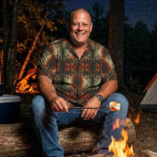 "The Call of Dracula" men’s Hawaiian shirt with vampire and castle graphic in monster aloha pattern; on model roasting a marshmallow over a campfire at night.
