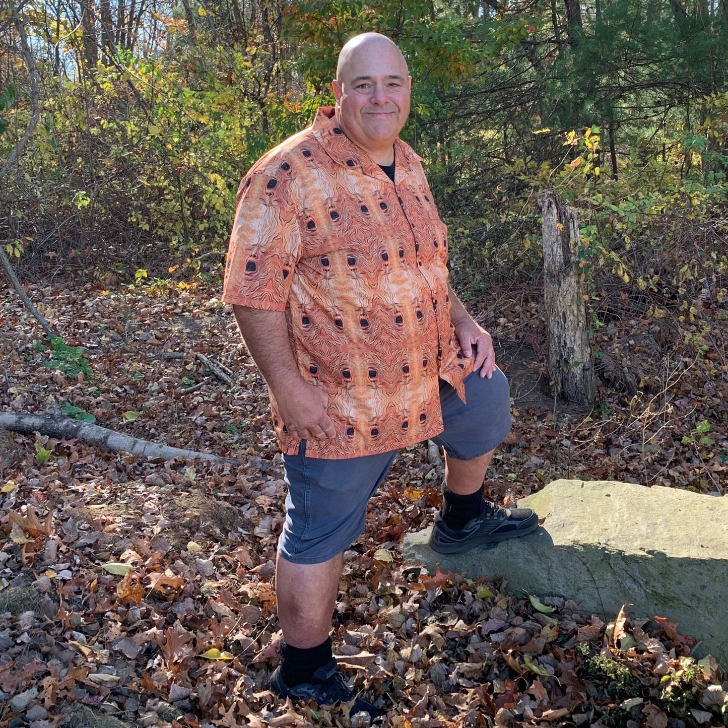 "The Necronomicon" men’s Hawaiian shirt with tormented face graphic in monster aloha pattern; front view; on Dan.